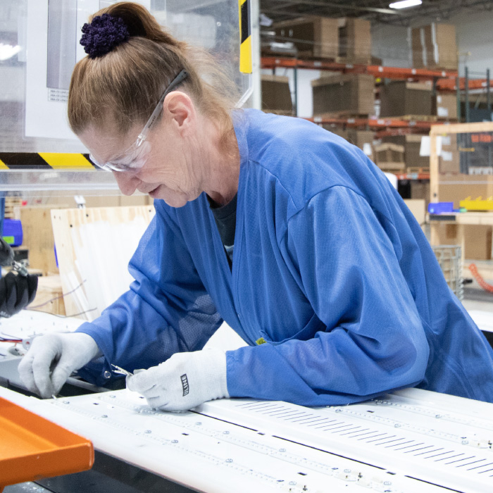 woman-building-fixture-in-production